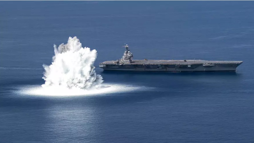 تاقیکردنەوەی بۆمبێکی گەورەی هێزی دەریایی ئەمریکا لە تەنیشت کەشتییەکی فڕۆکەهەڵگر